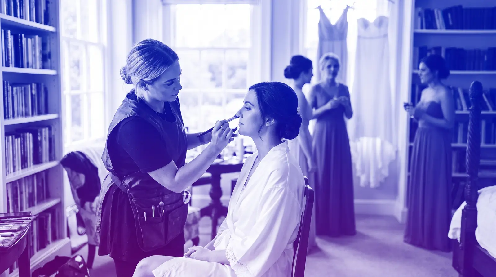 A makeup artist prepares a bride during morning wedding beauty prep