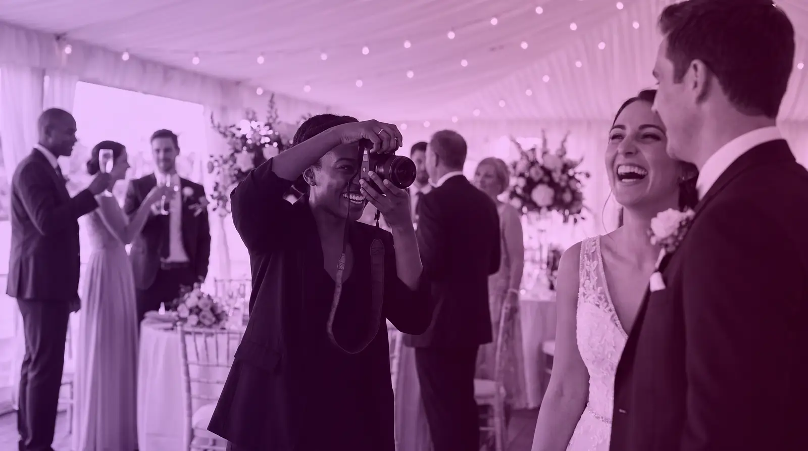 A Black wedding photographer captures a joyful moment at a reception