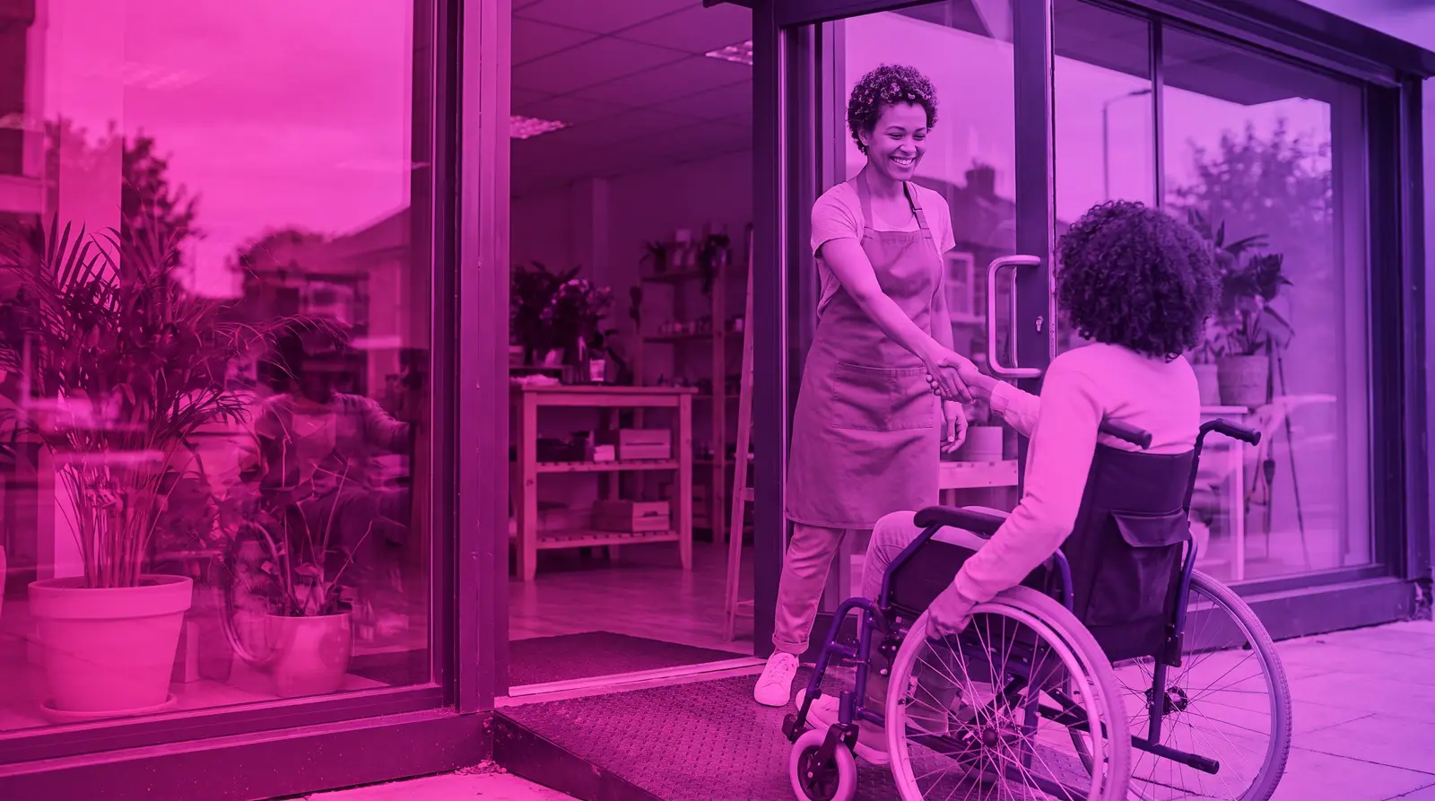 A small business owner welcomes a customer at an accessible storefront