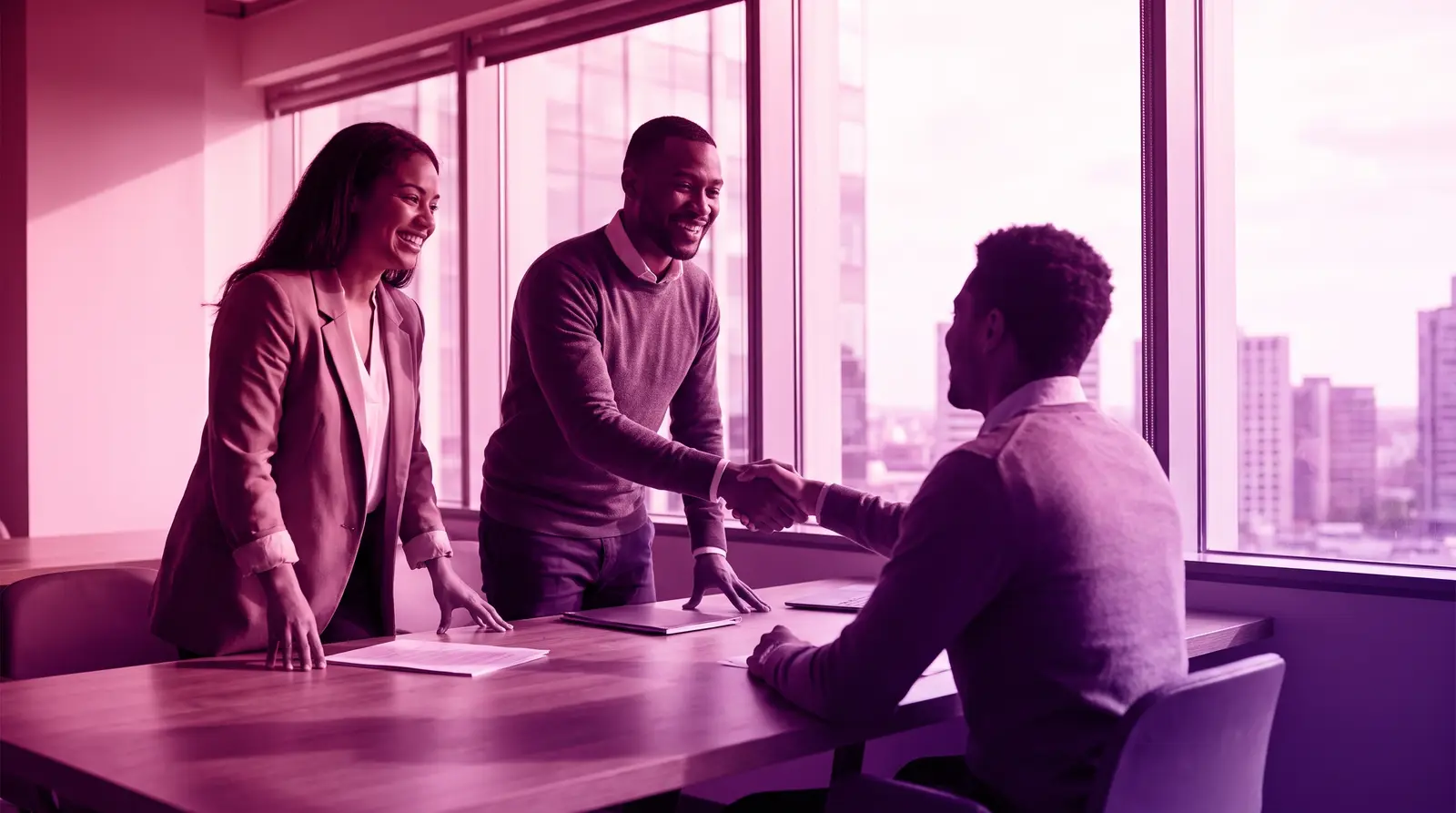 A diverse hiring panel talks with a candidate in a bright office