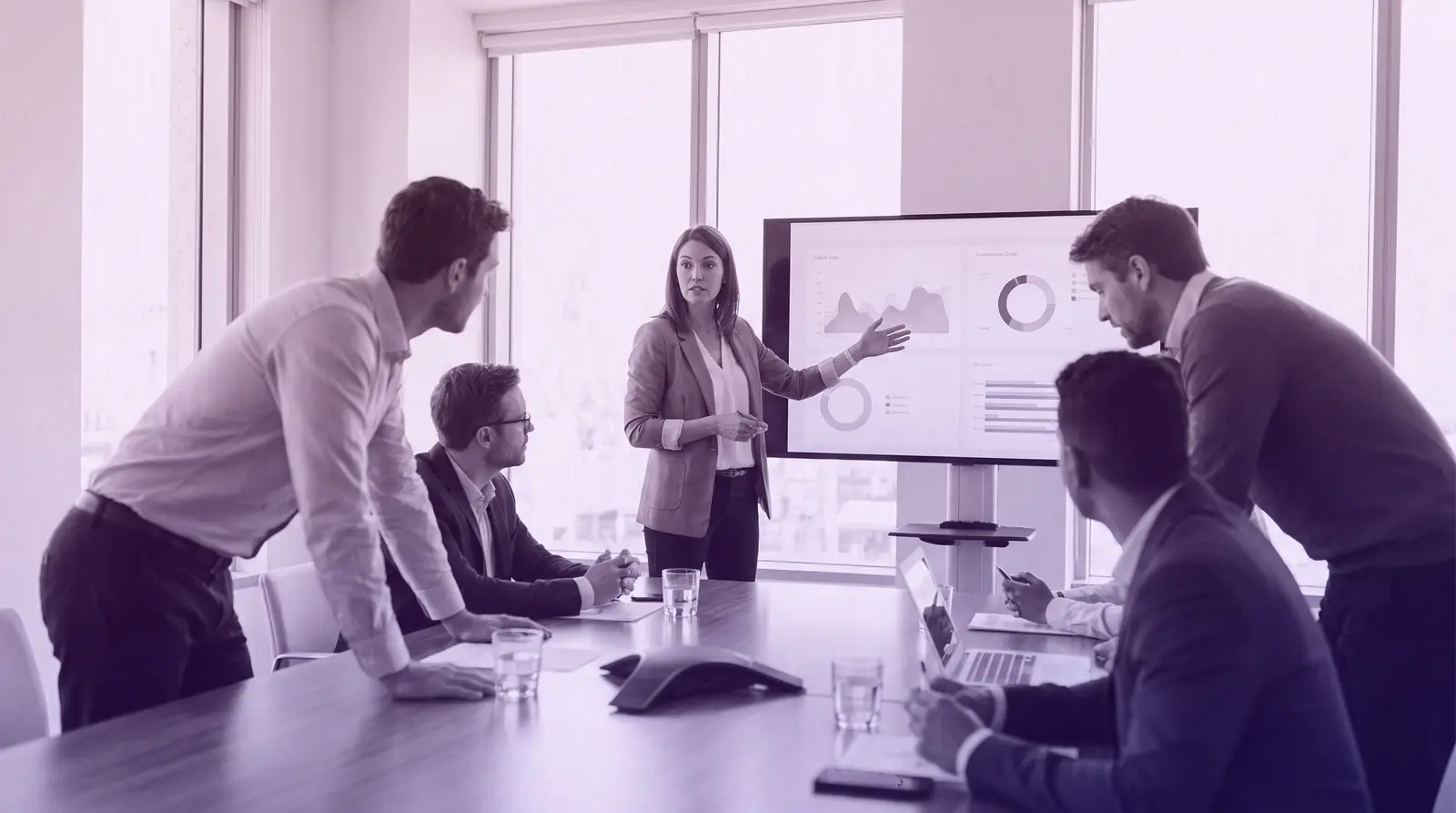 A woman leads a presentation to her team in a conference room