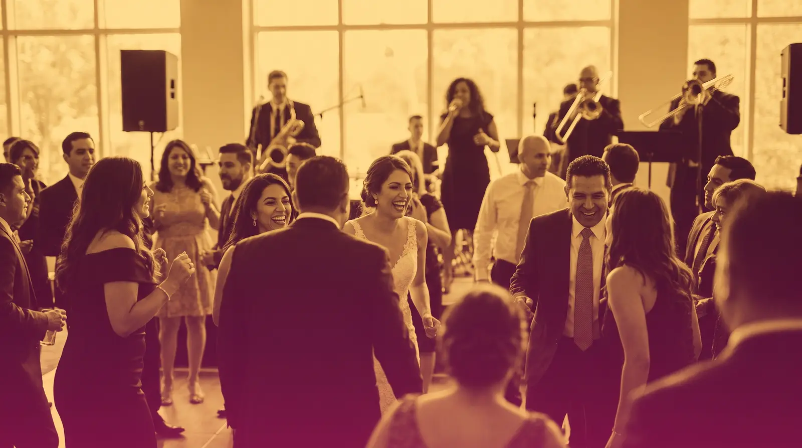 Guests dance at a lively Latino wedding reception with a live band