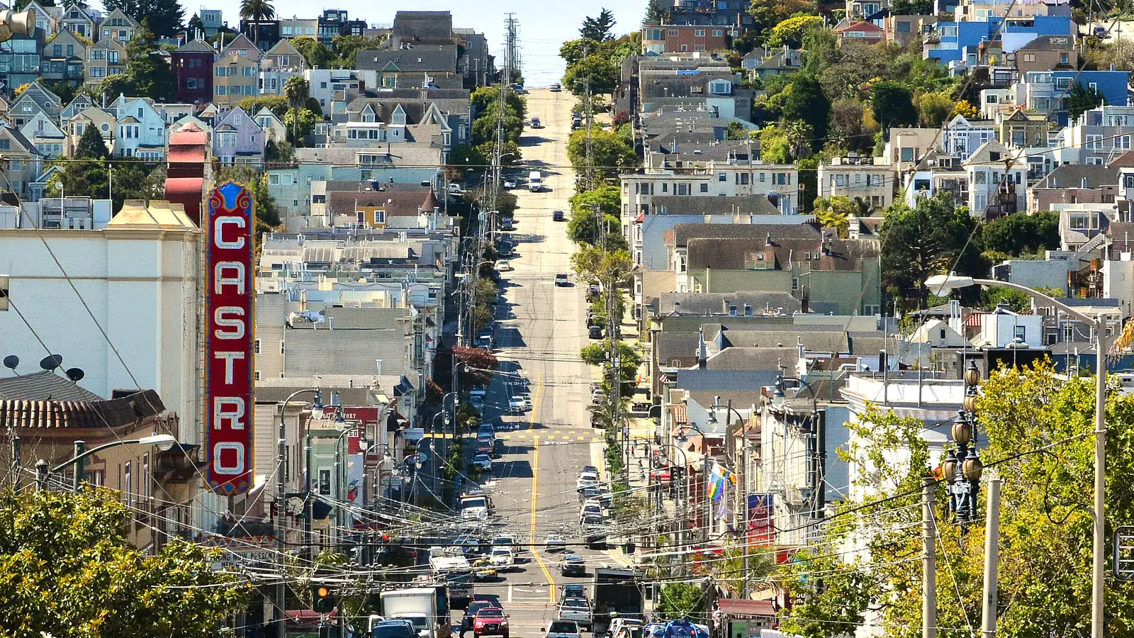 Castro Street in San Francisco running downhill past the Castro Theatre's vertical sign, with the city's hills behind