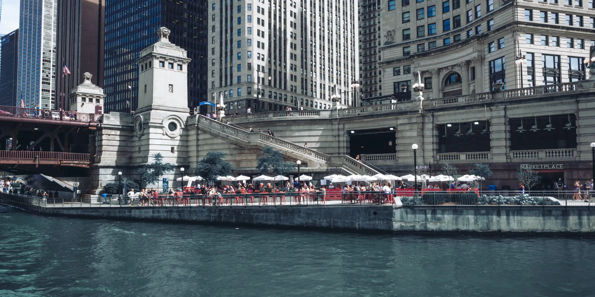 The Chicago Riverwalk below the Loop, with the DuSable Bridge behind it