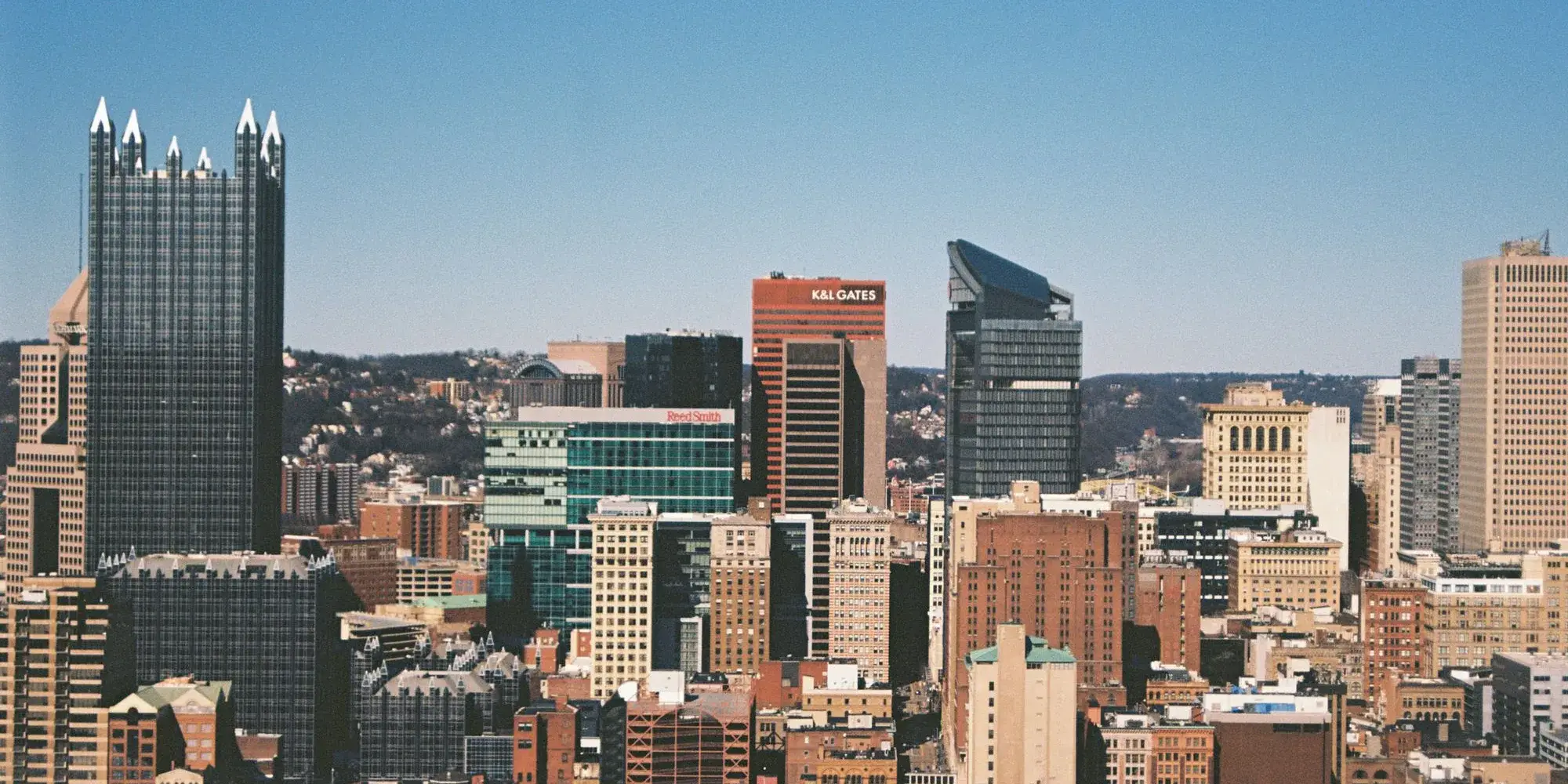 Downtown Pittsburgh under a clear sky with the glass spires of PPG Place