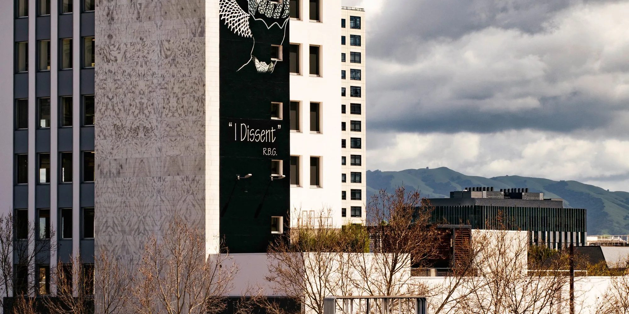 A mural on a building in downtown San Jose with the hills behind