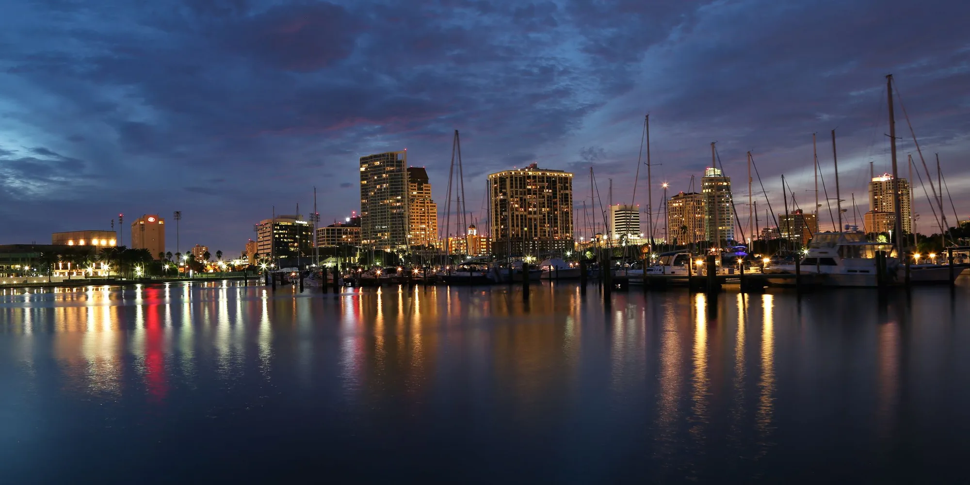 The downtown St. Petersburg waterfront at dusk, seen across the marina