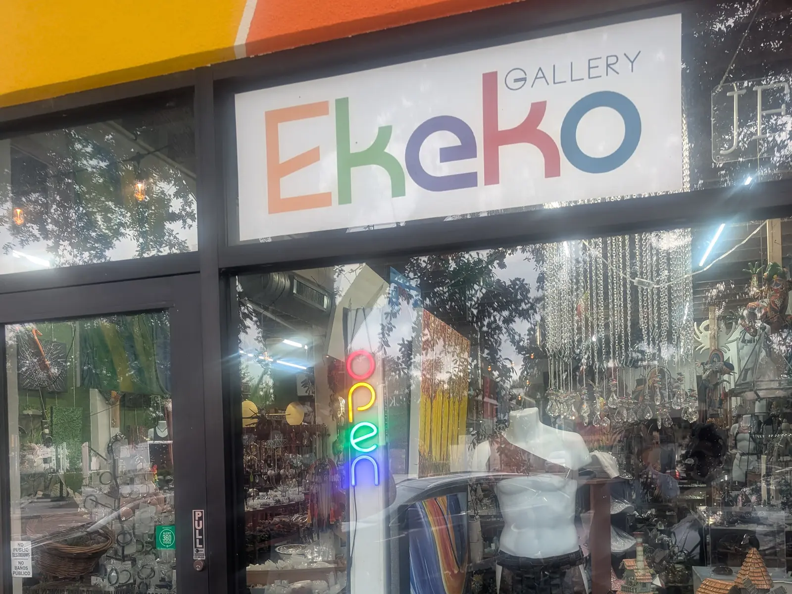 The Ekeko Gallery storefront in St. Petersburg, a neon open sign in the window above a display of jewelry and art